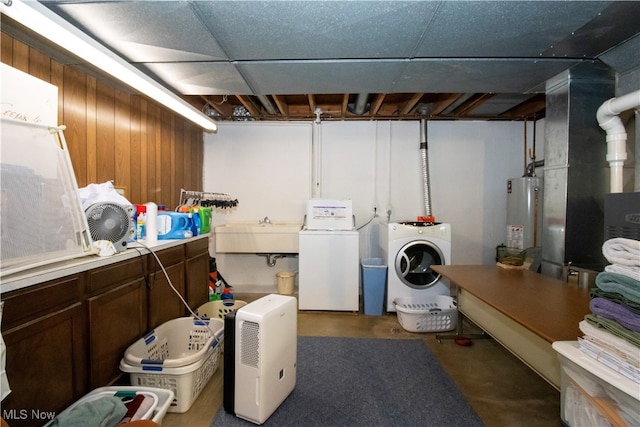 laundry area featuring washer and clothes dryer, gas water heater, and sink