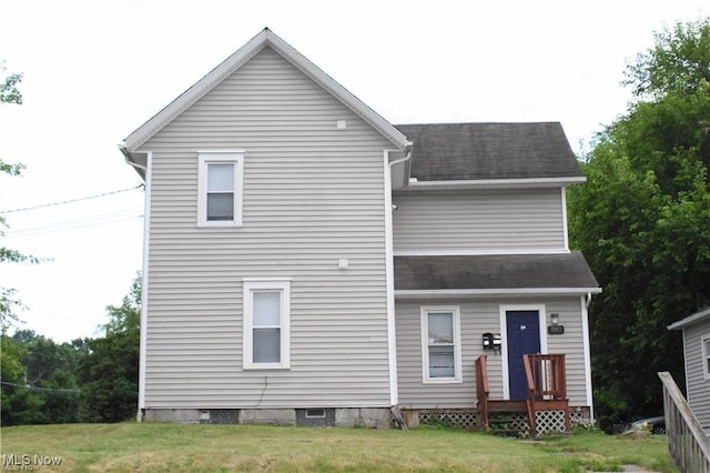 rear view of property with a lawn