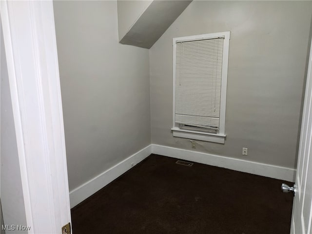 unfurnished room featuring vaulted ceiling