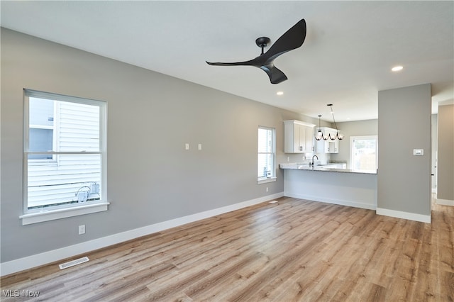 unfurnished living room with light hardwood / wood-style floors and sink