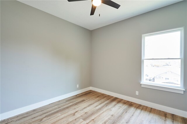 spare room featuring ceiling fan, light hardwood / wood-style flooring, and a healthy amount of sunlight