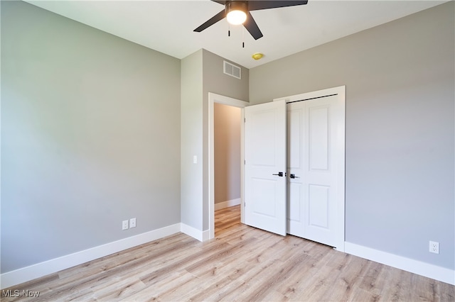 unfurnished bedroom with a closet, light hardwood / wood-style flooring, and ceiling fan