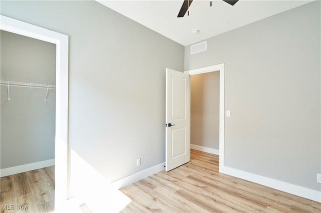 unfurnished bedroom featuring ceiling fan, a closet, and light hardwood / wood-style flooring