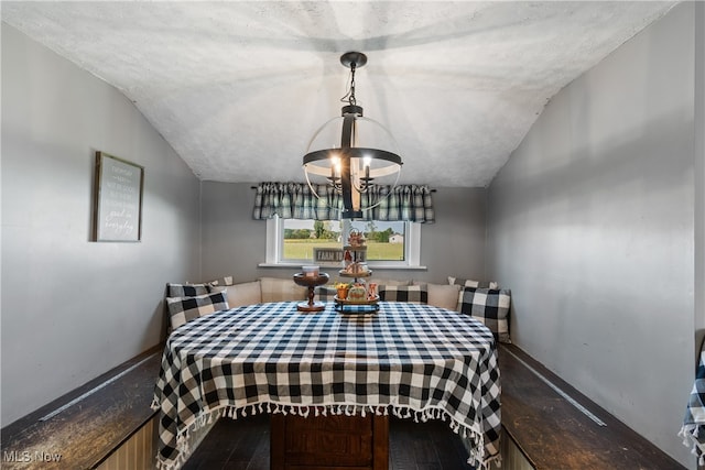 interior space featuring vaulted ceiling, an inviting chandelier, and hardwood / wood-style flooring