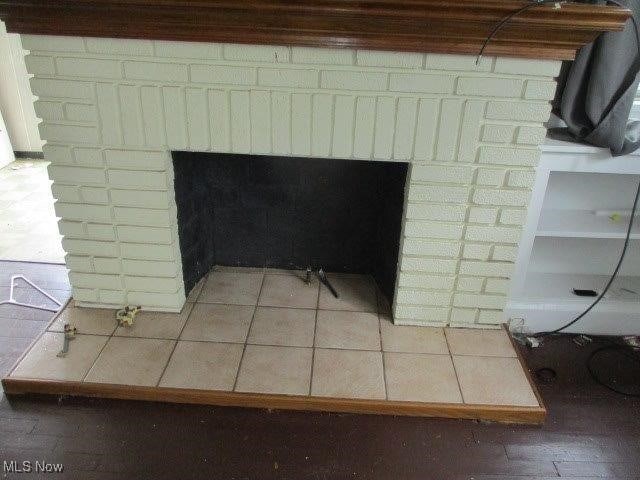 room details featuring tile patterned floors and a brick fireplace