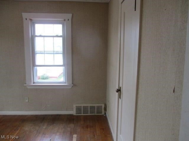 unfurnished room featuring dark wood-type flooring