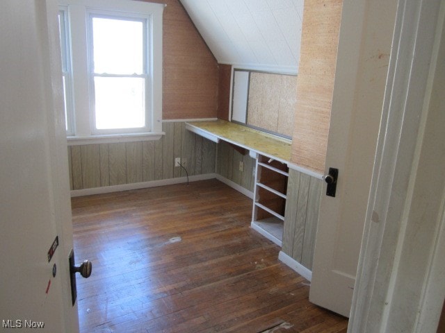 unfurnished office featuring vaulted ceiling and dark wood-type flooring