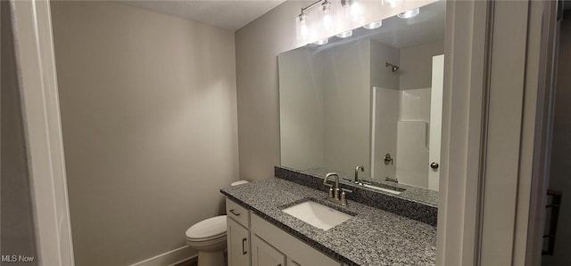 bathroom with vanity, toilet, and a shower