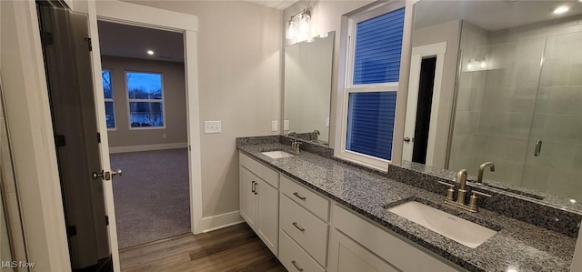 bathroom with hardwood / wood-style flooring, vanity, and a shower with shower door