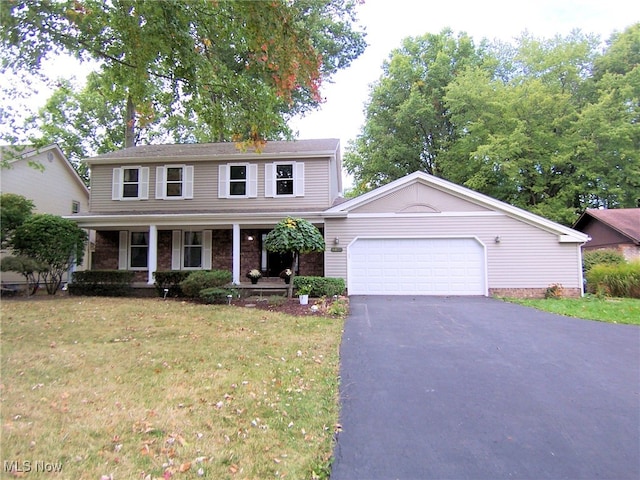 view of front of house featuring a front yard, a garage, and a porch