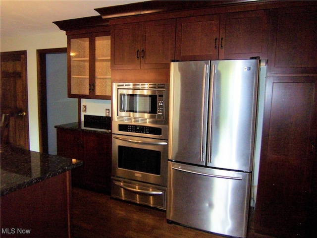 kitchen featuring dark stone countertops and appliances with stainless steel finishes