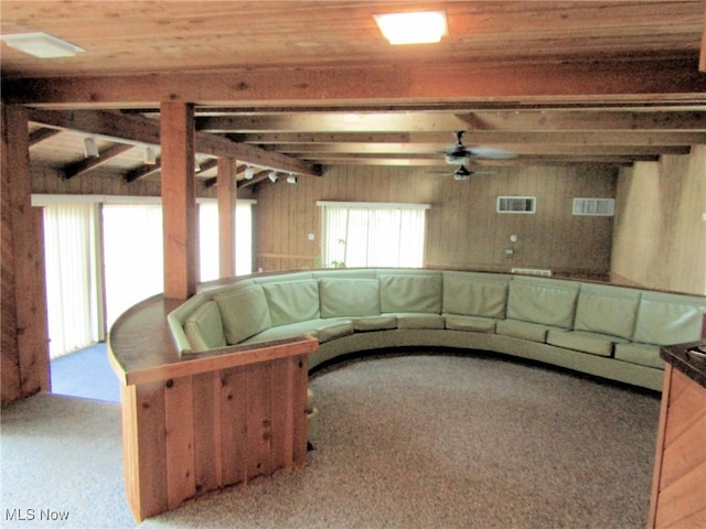 unfurnished living room with wooden ceiling, wood walls, ceiling fan, and light colored carpet