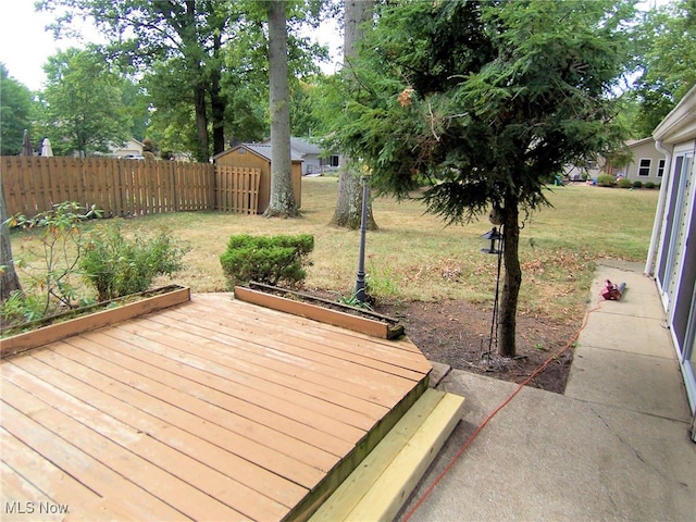 deck featuring a storage shed and a yard