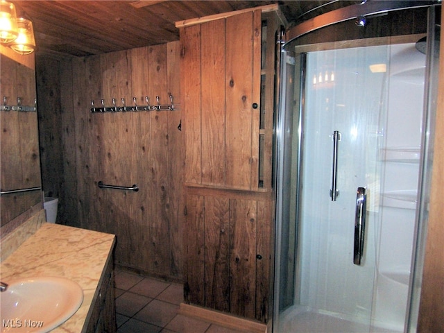 bathroom featuring a shower with shower door, wood walls, vanity, wooden ceiling, and tile patterned flooring