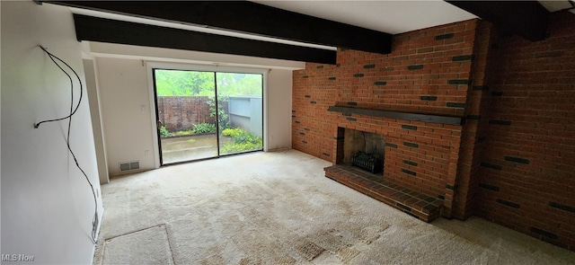 unfurnished living room featuring a brick fireplace, beamed ceiling, light carpet, and brick wall