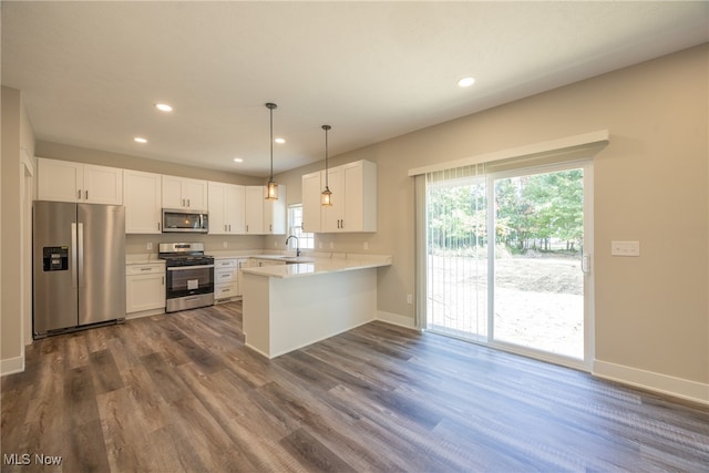 kitchen with sink, kitchen peninsula, dark wood-type flooring, white cabinetry, and stainless steel appliances