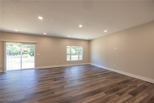 unfurnished room featuring a textured ceiling and dark wood-type flooring