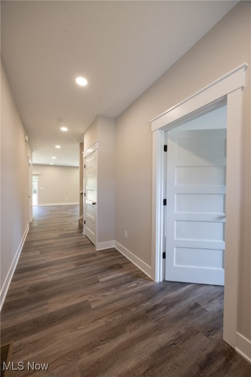 hallway with dark hardwood / wood-style flooring