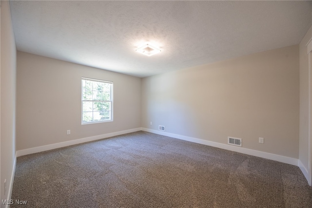 unfurnished room with a textured ceiling and carpet flooring