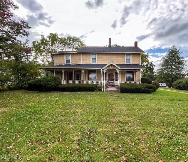 view of front facade with covered porch and a front yard