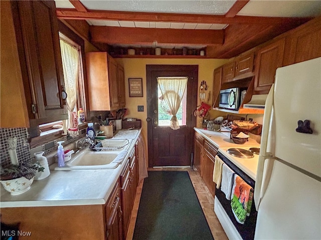 kitchen featuring dark tile patterned flooring, sink, beam ceiling, white appliances, and tasteful backsplash