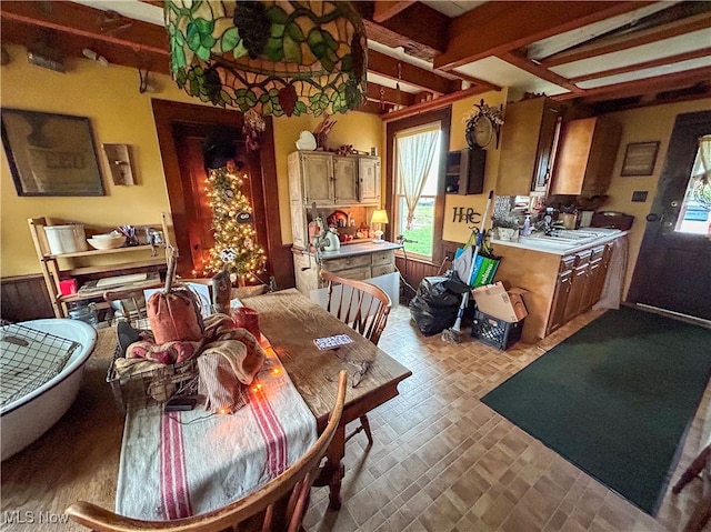 dining room with beam ceiling, plenty of natural light, and sink