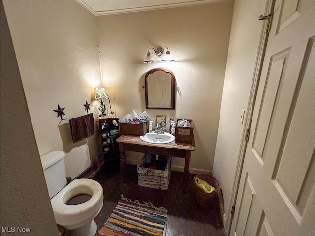 bathroom featuring wood-type flooring, toilet, and sink