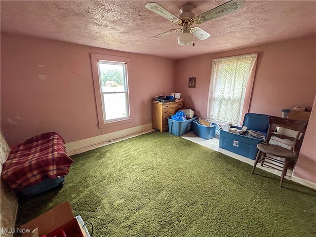 interior space with ceiling fan, carpet floors, and a textured ceiling