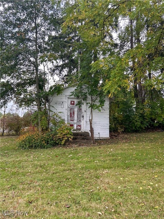 view of front of house with a shed and a front yard