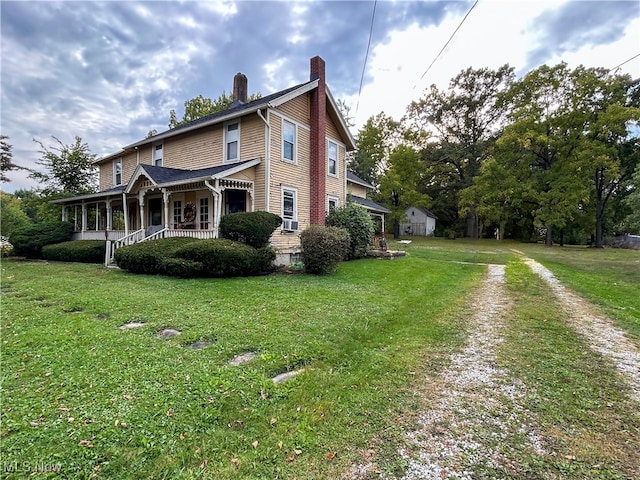 view of side of home with a lawn, cooling unit, and a porch