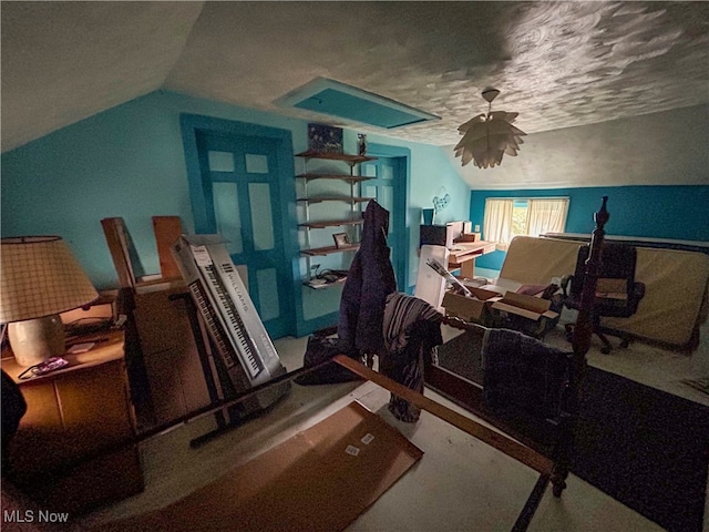 miscellaneous room with lofted ceiling and a textured ceiling