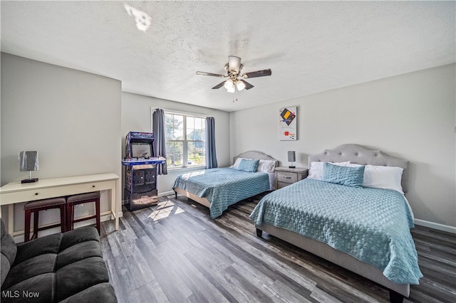 bedroom with a textured ceiling, ceiling fan, and dark wood-type flooring