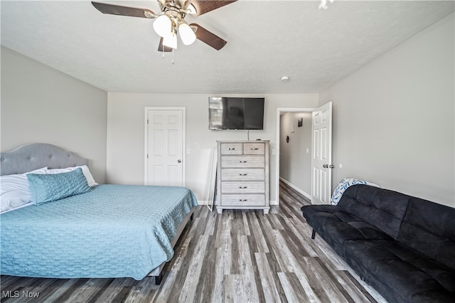 bedroom featuring a textured ceiling, dark hardwood / wood-style flooring, and ceiling fan