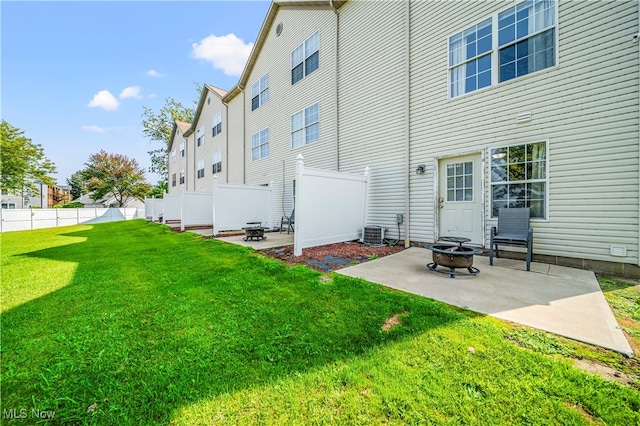 exterior space with central air condition unit, a lawn, a patio area, and an outdoor fire pit