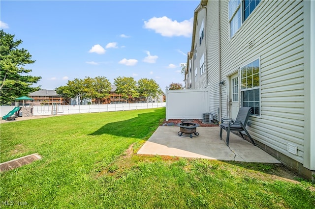 view of yard with a playground, an outdoor fire pit, a patio area, and central AC