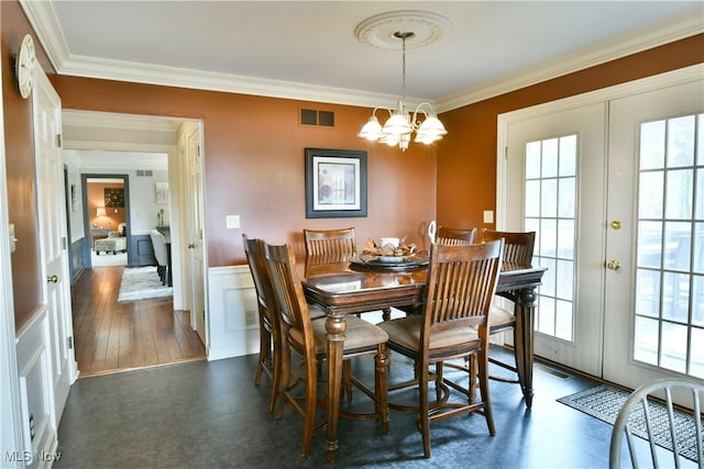 dining area with an inviting chandelier, dark hardwood / wood-style floors, french doors, and crown molding