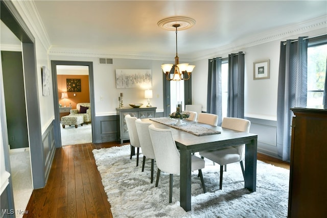 dining space featuring ornamental molding, a chandelier, and dark hardwood / wood-style flooring