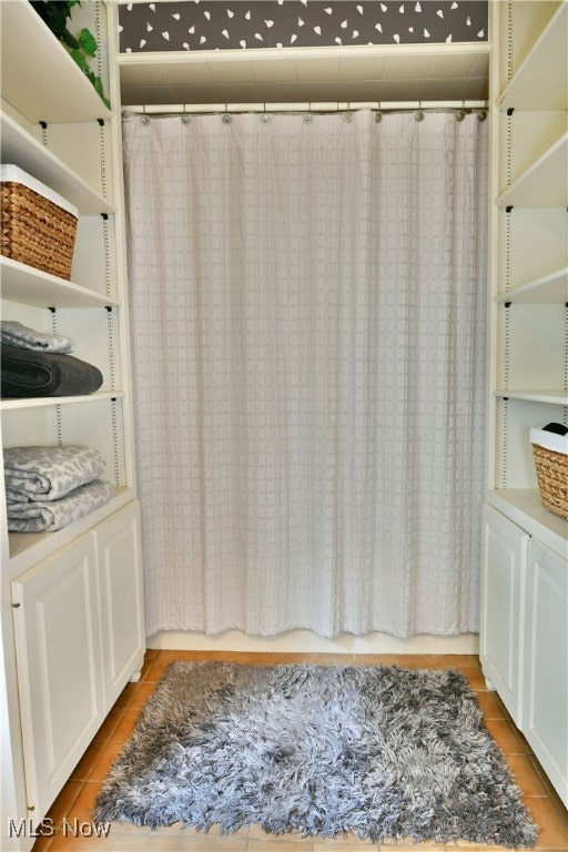 interior space with vanity, tile patterned floors, and a shower with curtain