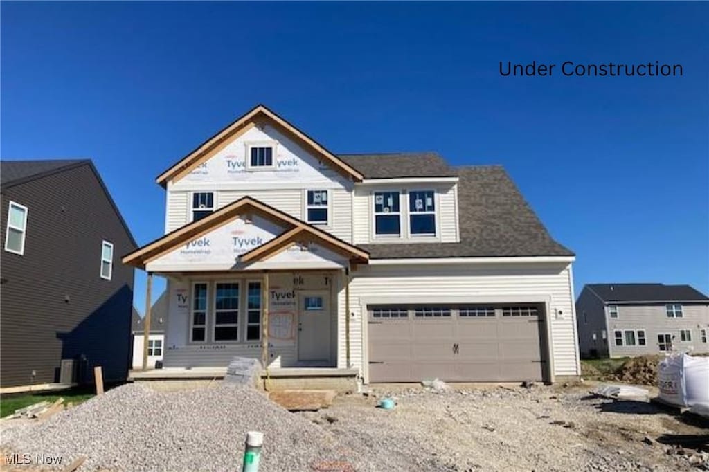 view of front of house with central air condition unit and a garage