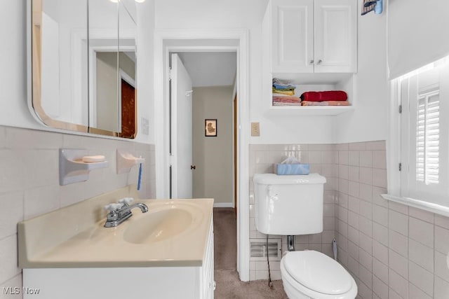 bathroom featuring vanity, tile walls, and toilet