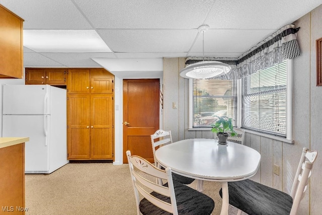 carpeted dining room featuring a paneled ceiling