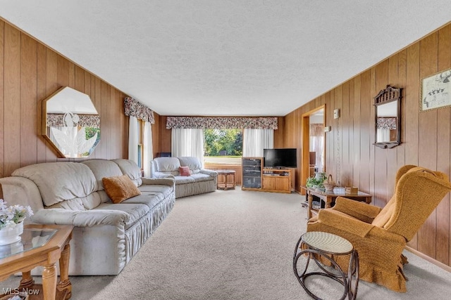 carpeted living room featuring a textured ceiling and wooden walls