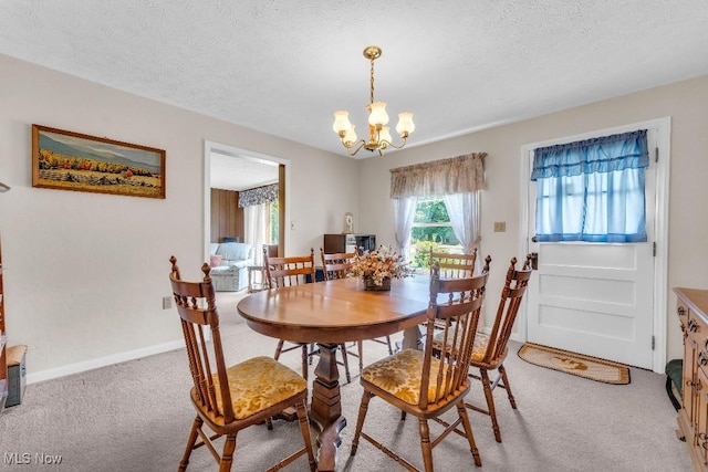 dining room with carpet, a textured ceiling, and an inviting chandelier