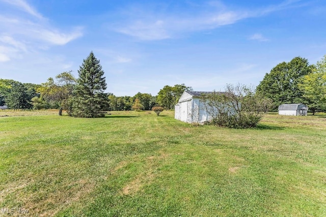 view of yard with a rural view and a shed