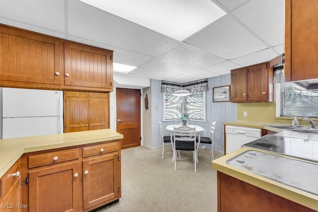 kitchen featuring a drop ceiling, white appliances, and sink