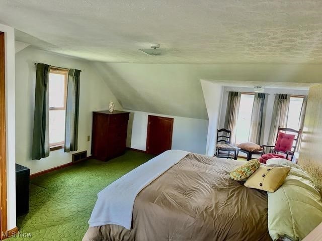 bedroom with dark carpet, a textured ceiling, and vaulted ceiling