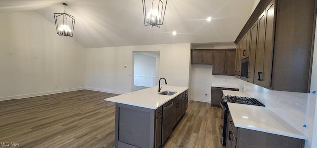 kitchen featuring lofted ceiling, a kitchen island with sink, hanging light fixtures, dark hardwood / wood-style floors, and appliances with stainless steel finishes