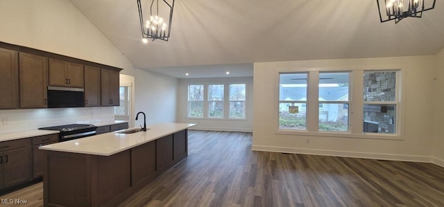 kitchen with an island with sink, decorative light fixtures, an inviting chandelier, and sink