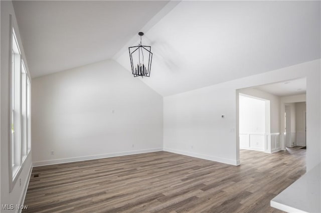 interior space featuring an inviting chandelier, hardwood / wood-style flooring, and vaulted ceiling