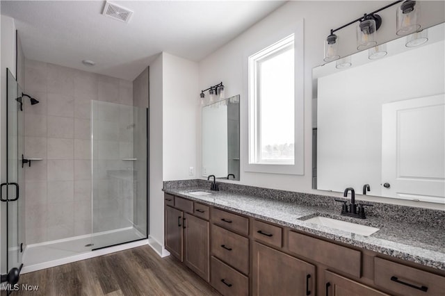 bathroom featuring hardwood / wood-style flooring, vanity, and walk in shower